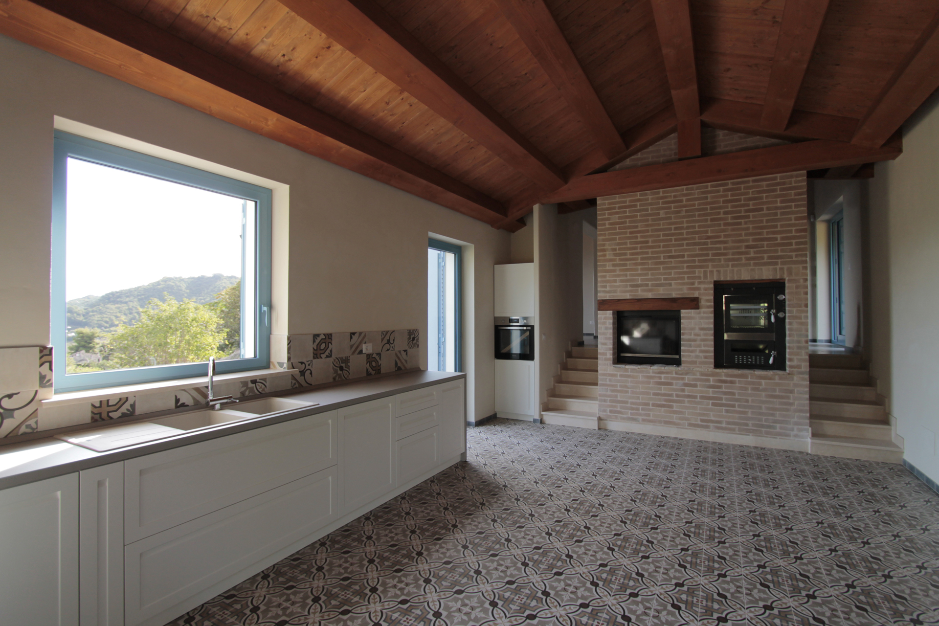 Casa di campagna - interno - cucina con tetto in legno e camino - cucina Scavolini - pavimento in gres effetto cementine
