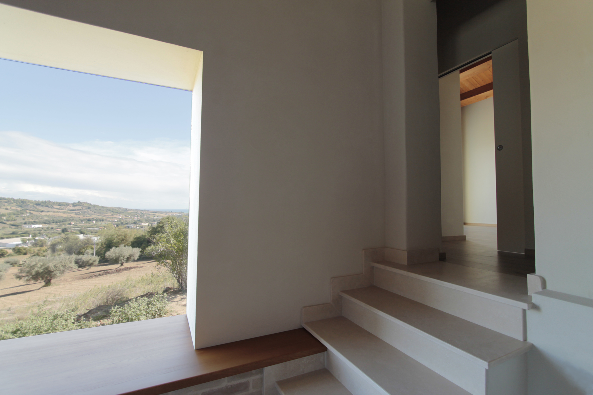 Casa di campagna - interno - finestra baywindow con seduta in legno e vista sul paesaggio collinare ed il mare adriatico